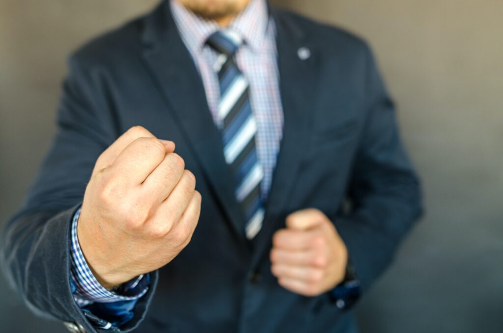 A man in a business suit holding out a fist
