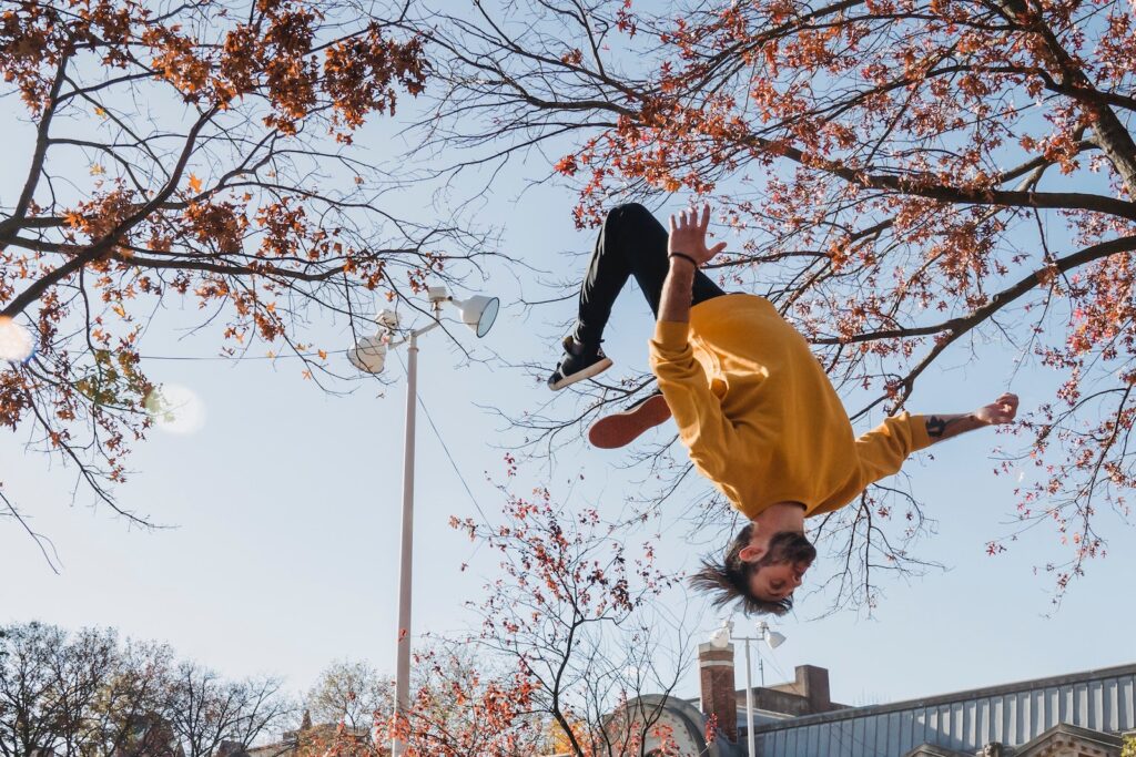 A young man flipping in a park