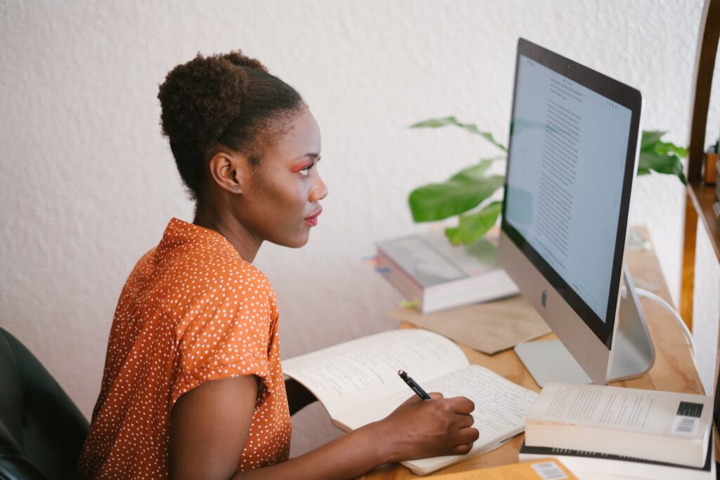 A young woman seated at her computer cramming for an exam