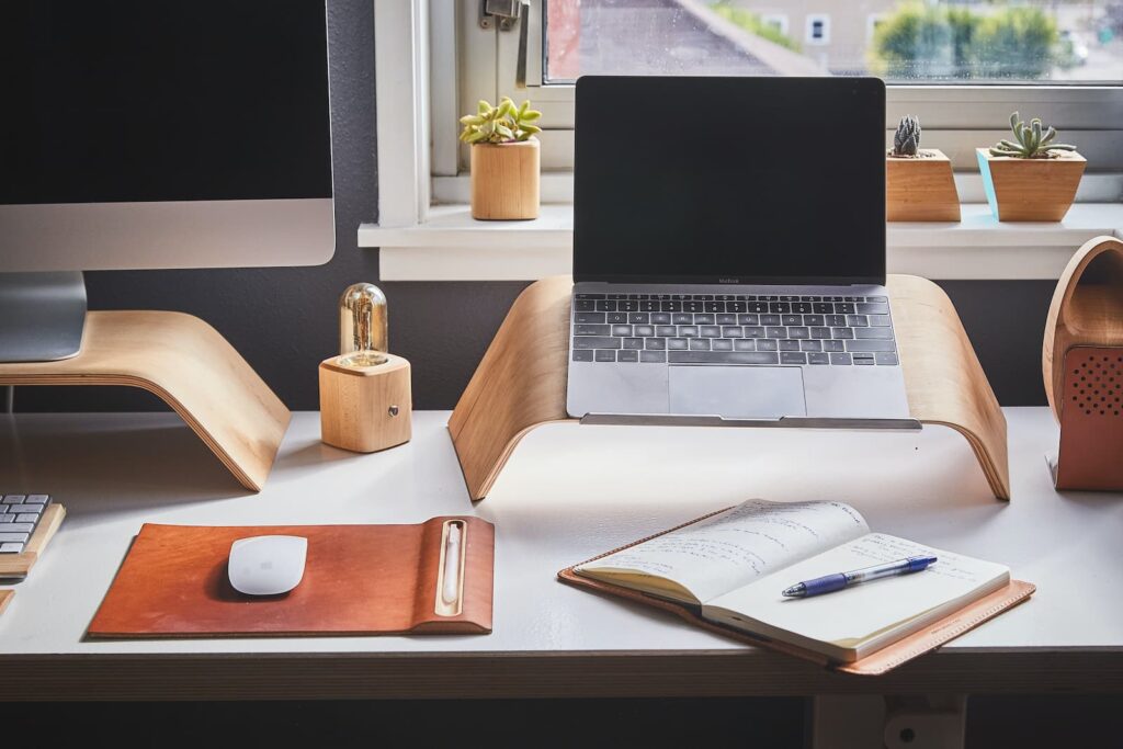 Computers and a notepad on a desk in someone's work-from-home office