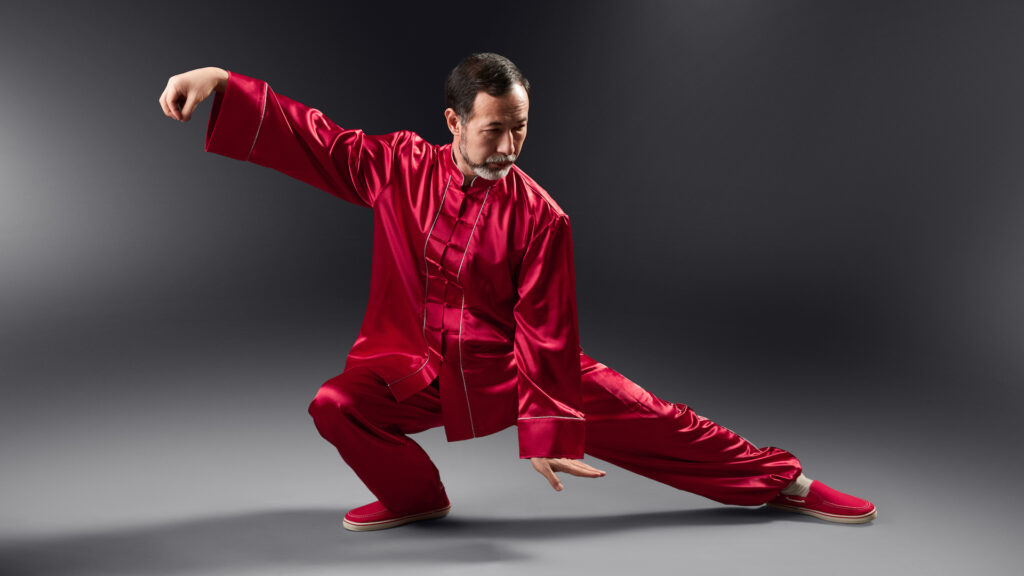 A Tai Chi master practicing in traditional Chinese clothing