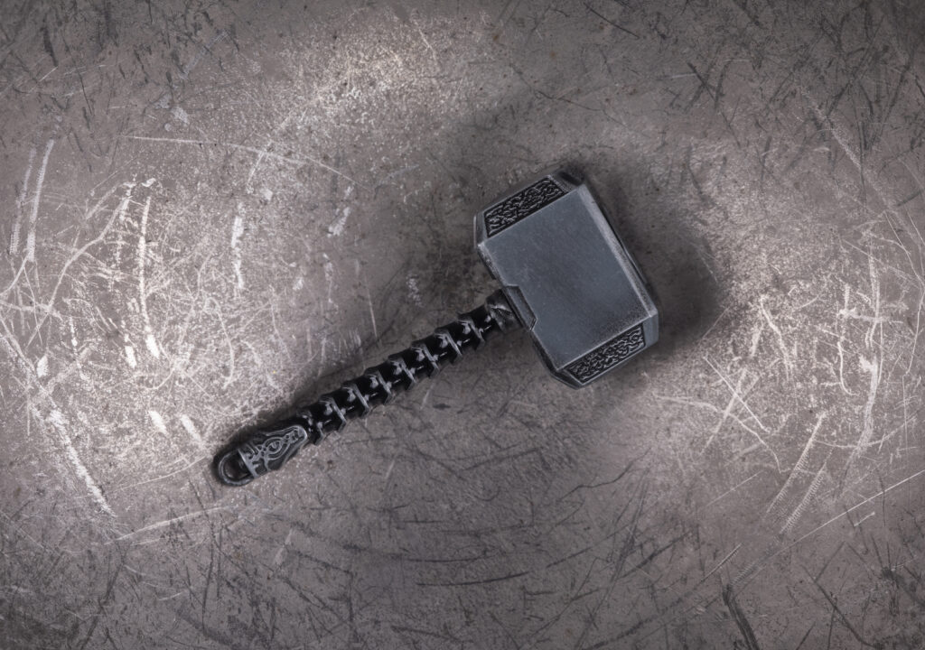 Thor's hammer resting on a gray background
