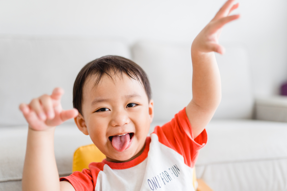 A young boy sticking out his tongue and acting strange