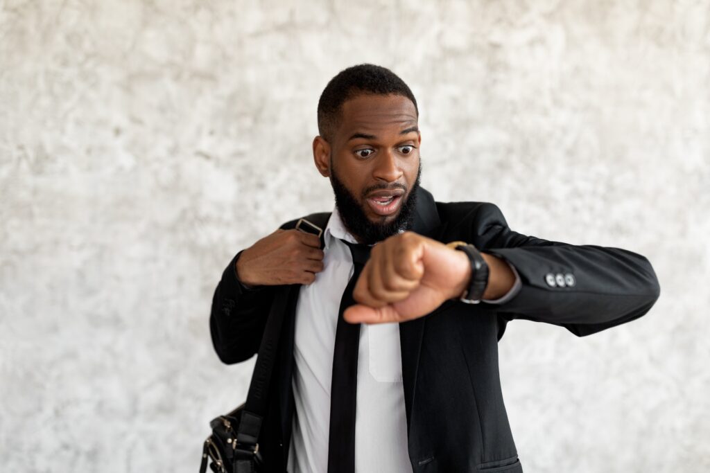 A businessman looking at his watch and needing to reschedule a meeting