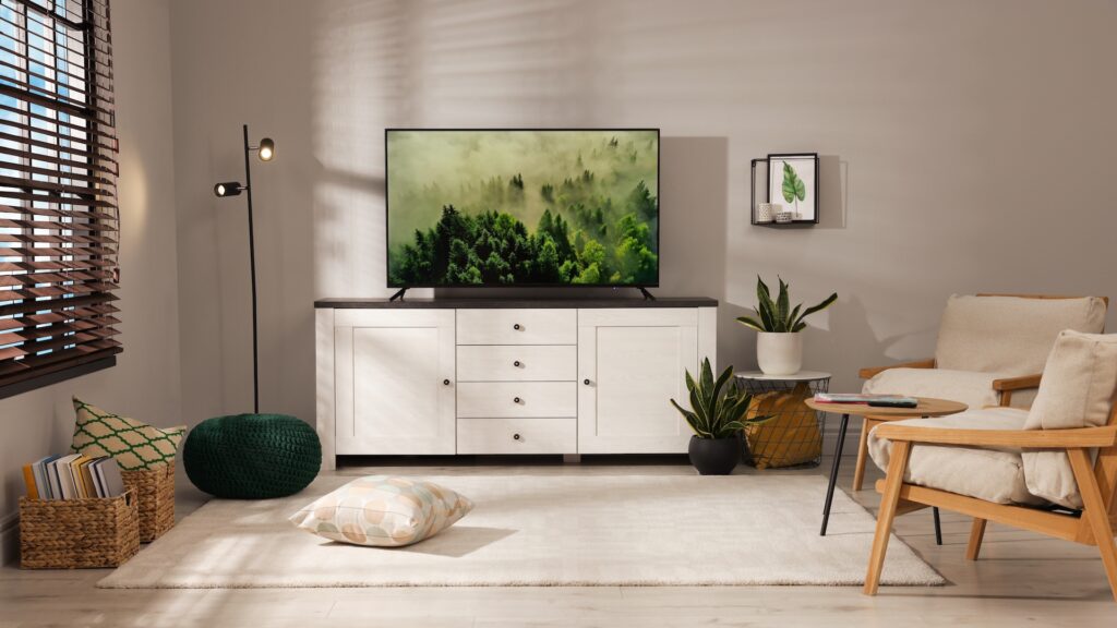 A cozy living room with plants beside a TV stand