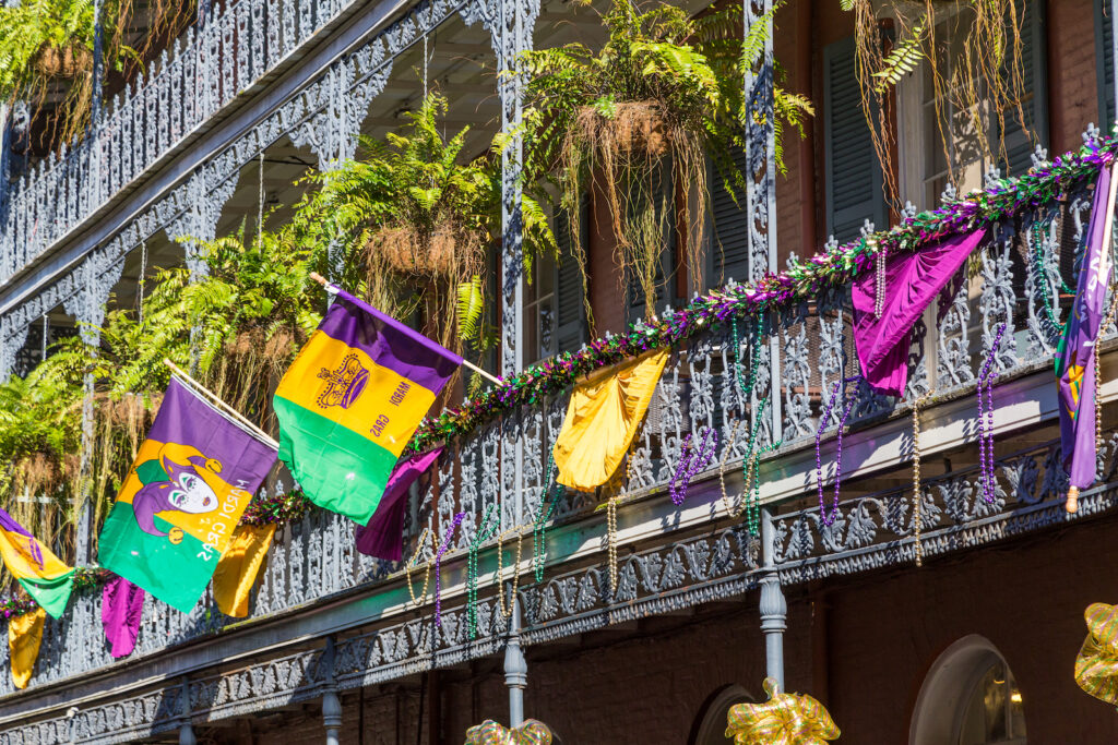 A building in New Orleans' French Quarter decorated with colorful flags and beads for Mardi Gras