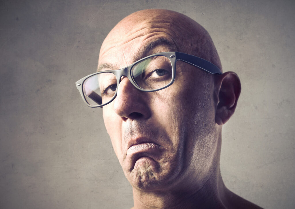 A snobby, bald man looking down his nose at someone