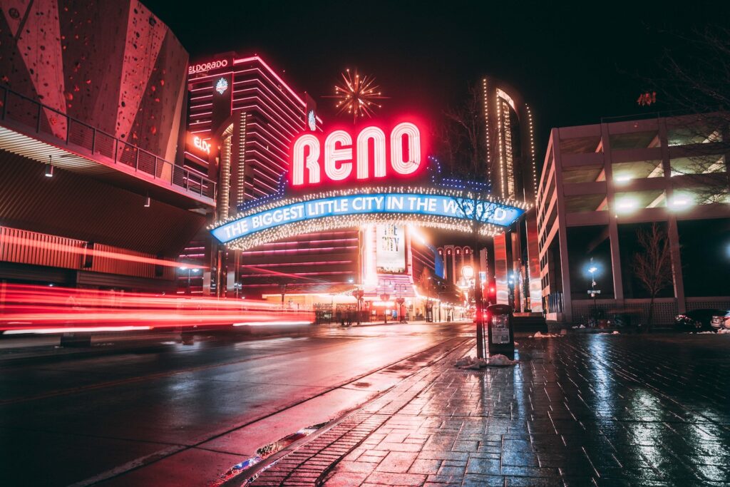 A bright neon sign advertising Reno at night