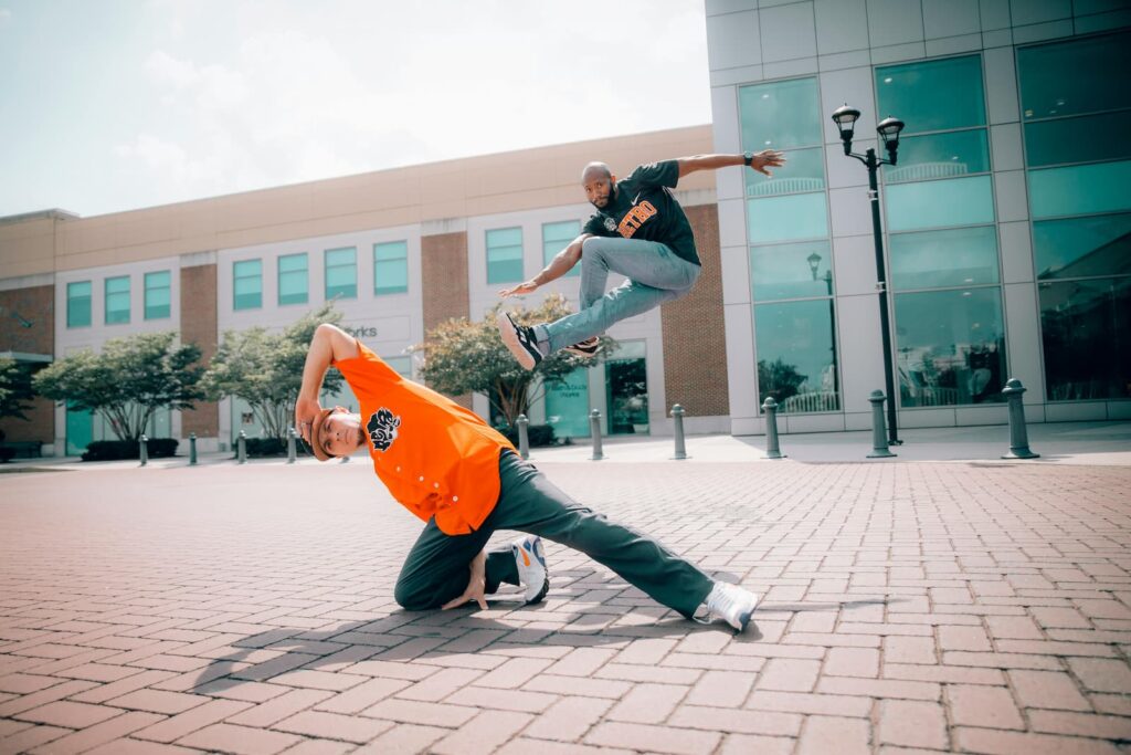 Two b-boys dancing outdoors in front of an office building
