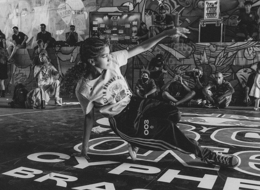 A b-girl dancing in the center of an audience