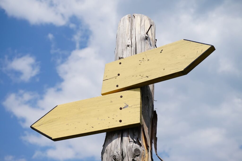 Two wooden arrow signs pointing in opposite directions